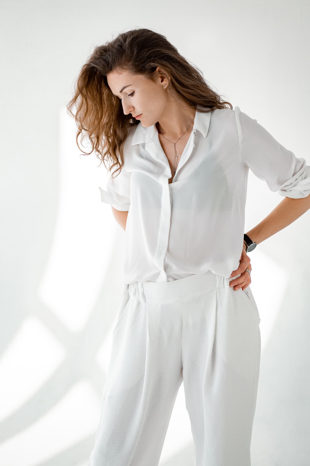 Woman in white linen standing in soft daylight