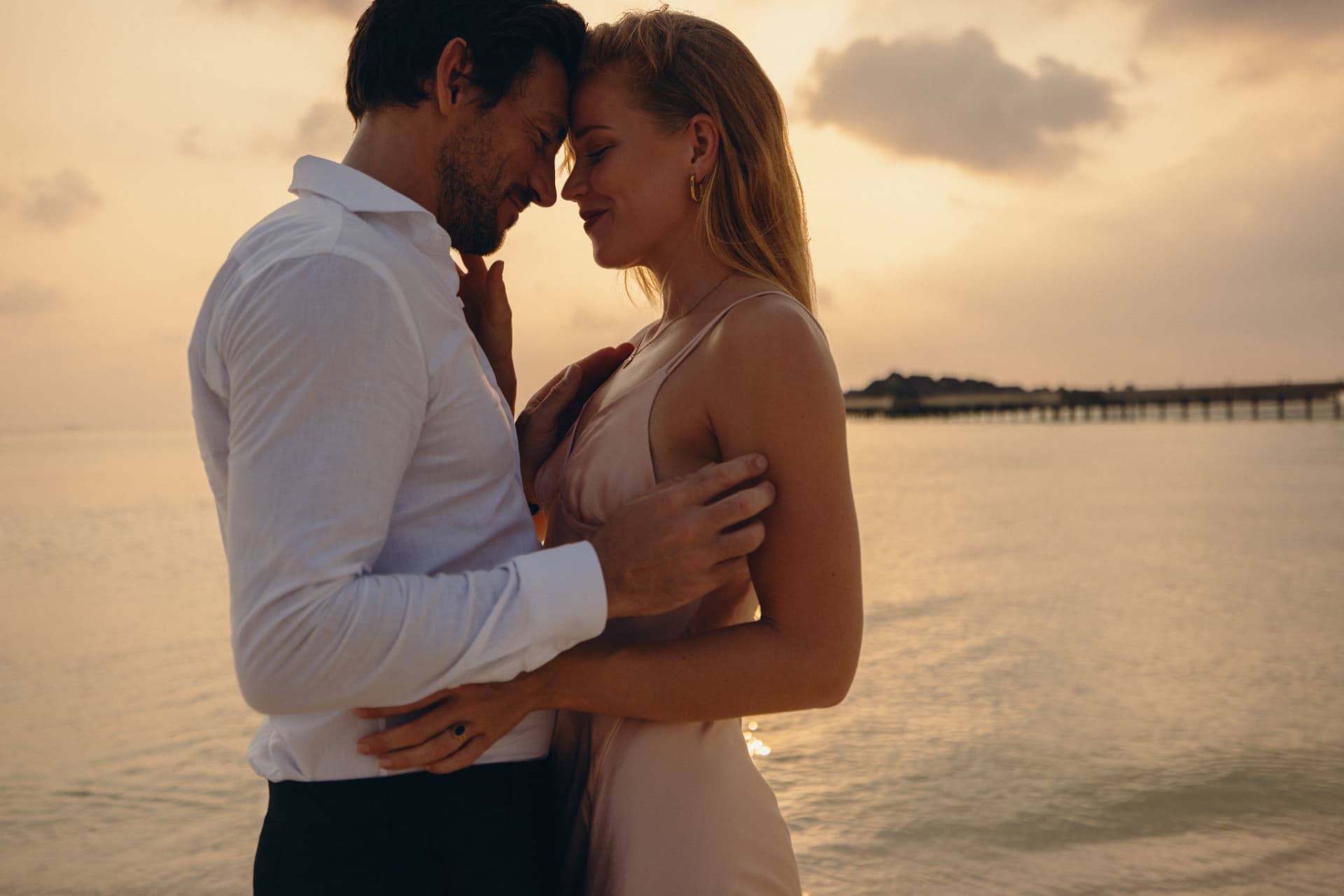 Couple embracing at sunset by the water