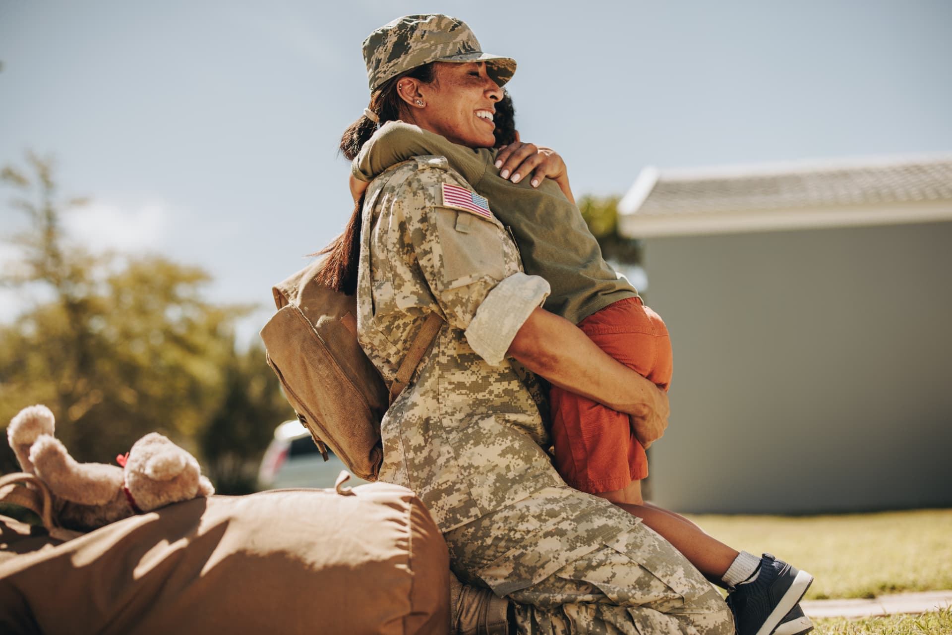 Servicewoman in uniform hugging her child at homecoming